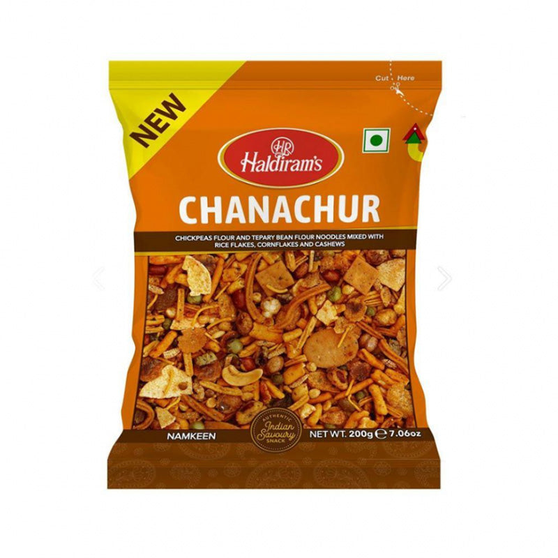 A package of Haldiram's Chanachur, a crispy snack mix, with a clear view of the product through the transparent front. The package is primarily orange and white with text and branding.