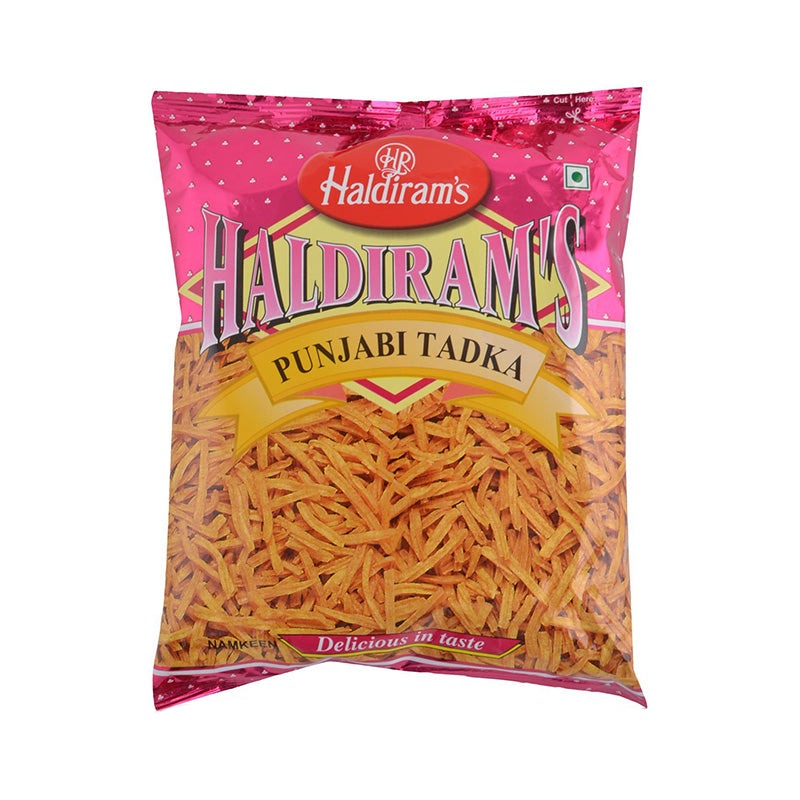 A package of Haldiram's Punjabi Tadka, showing the product name and the snack's visible ingredients like chips and peanuts through the transparent packaging.